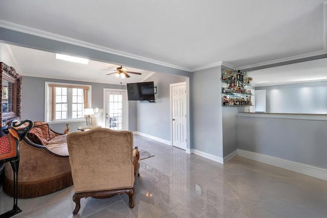 living area with baseboards, ornamental molding, a ceiling fan, and a dry bar