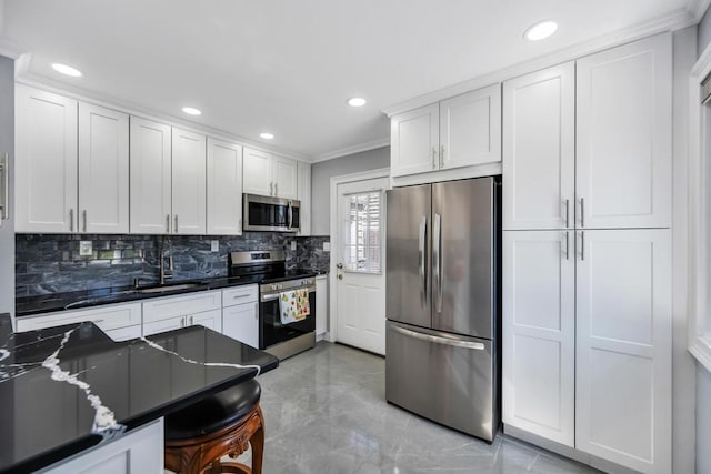 kitchen with crown molding, dark countertops, a sink, appliances with stainless steel finishes, and backsplash