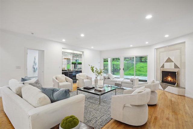 living room featuring recessed lighting, light wood-style flooring, and a fireplace