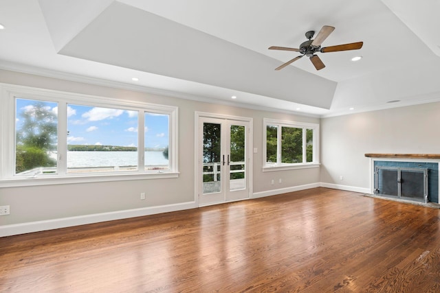 145 Asharoken Ave, Northport, NY 11768 - unfurnished living room featuring a raised ceiling, a healthy amount of sunlight, a fireplace, and wood finished floors
