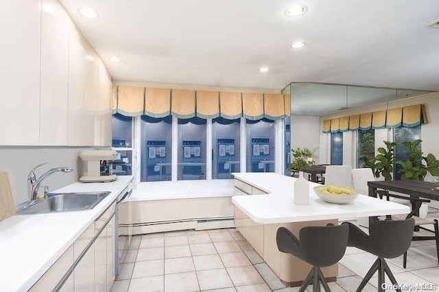 2872 Rosebud Ave, Merrick, NY 11566 - kitchen featuring white cabinetry, light countertops, light tile patterned floors, and a sink