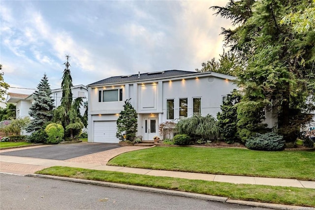 2872 Rosebud Ave, Merrick, NY 11566 - view of front of property with aphalt driveway, stucco siding, an attached garage, and a front yard