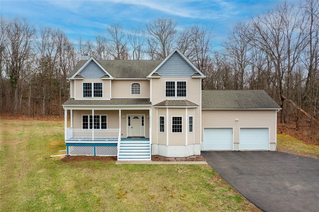 view of front of property with driveway, a front yard, roof with shingles, a garage, and a porch