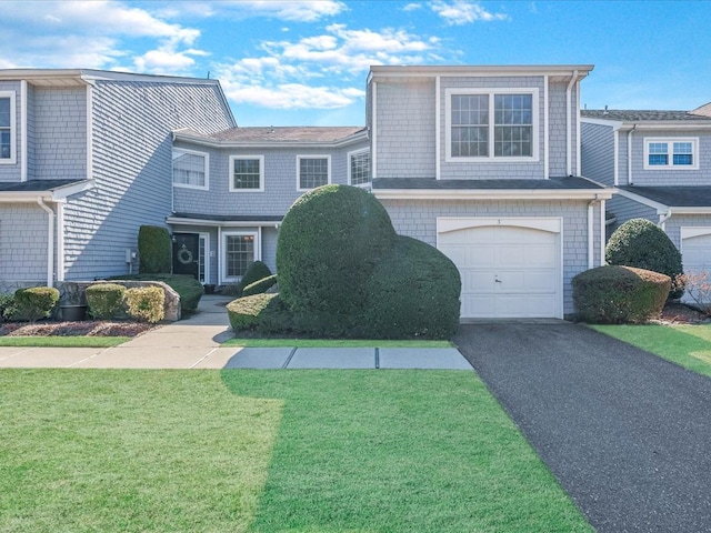 view of front of house with aphalt driveway, an attached garage, and a front lawn