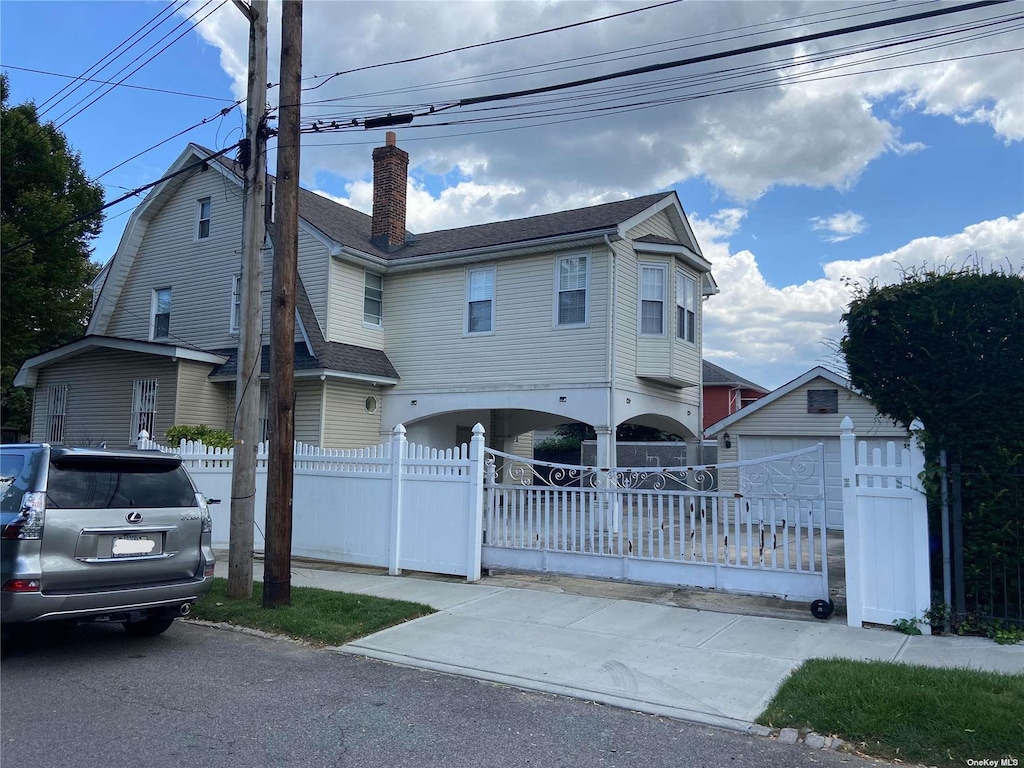 89-34 197th St, Hollis, NY 11423 - view of front facade with a fenced front yard, a chimney, an outdoor structure, and a shingled roof