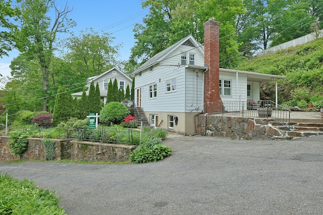 24 Burnsdale Ave, Valhalla, NY 10595 - view of property exterior with a chimney, asphalt driveway, and a porch