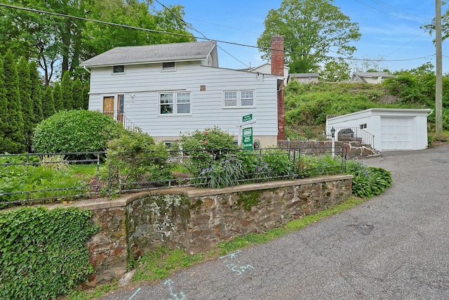 24 Burnsdale Ave, Valhalla, NY 10595 - view of side of home with an outbuilding, a chimney, and a detached garage