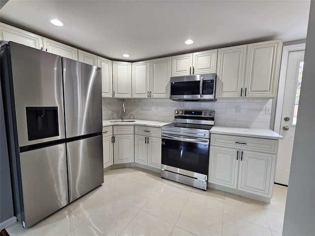 kitchen with decorative backsplash, light stone countertops, appliances with stainless steel finishes, and a sink
