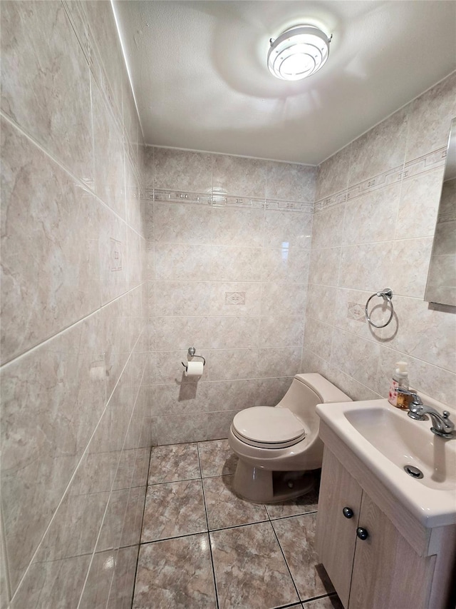 159-42 81st St, Howard Beach, NY 11414 - bathroom with tile walls, tile patterned floors, vanity, and toilet