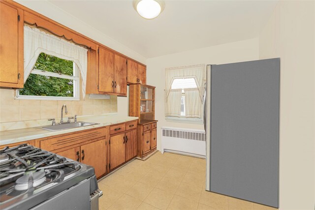 3476 Bruner Ave, Bronx, NY 10469 - kitchen with a sink, radiator heating unit, a wealth of natural light, and stainless steel appliances