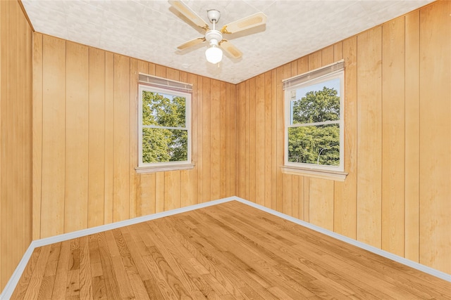 3476 Bruner Ave, Bronx, NY 10469 - empty room with baseboards, a ceiling fan, wood finished floors, and wooden walls