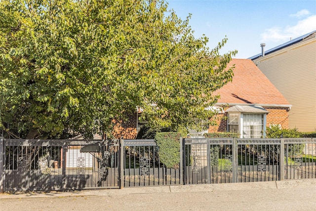 3476 Bruner Ave, Bronx, NY 10469 - view of front of home featuring brick siding, a shingled roof, and a fenced front yard