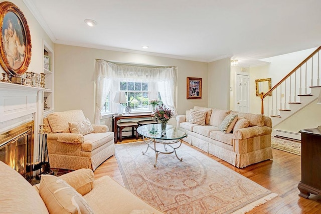 28 Rose Ave, Great Neck, NY 11021 - living room featuring crown molding, a baseboard radiator, wood finished floors, stairway, and a glass covered fireplace