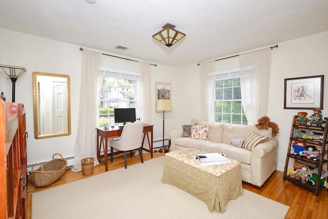 28 Rose Ave, Great Neck, NY 11021 - living room featuring a baseboard radiator, healthy amount of natural light, wood finished floors, and an office area