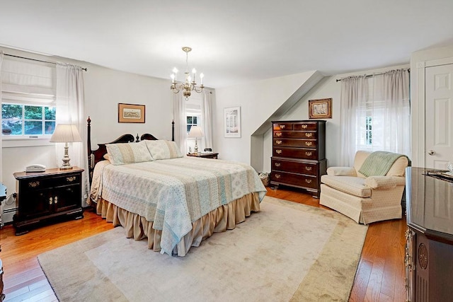 28 Rose Ave, Great Neck, NY 11021 - bedroom featuring light wood-style floors, a chandelier, and baseboard heating