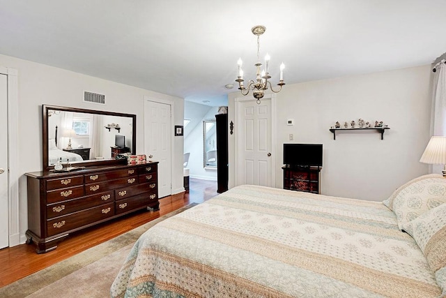 28 Rose Ave, Great Neck, NY 11021 - bedroom with a chandelier, wood finished floors, and baseboards