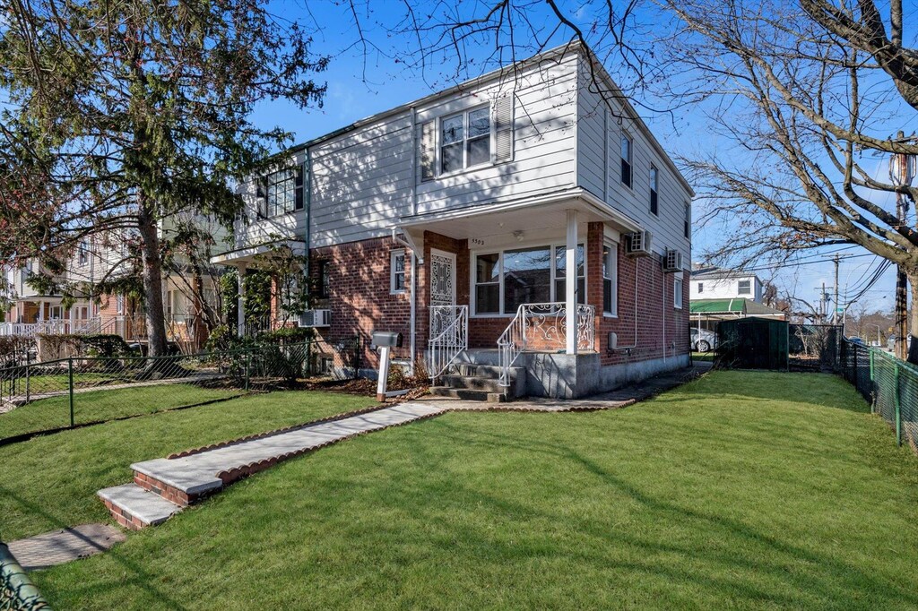 53-02 207th St, Oakland Gardens, NY 11364 - view of front facade with covered porch, a fenced backyard, brick siding, and a front lawn