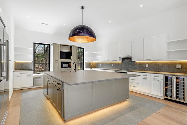kitchen featuring white cabinetry, oven, open shelves, and wine cooler