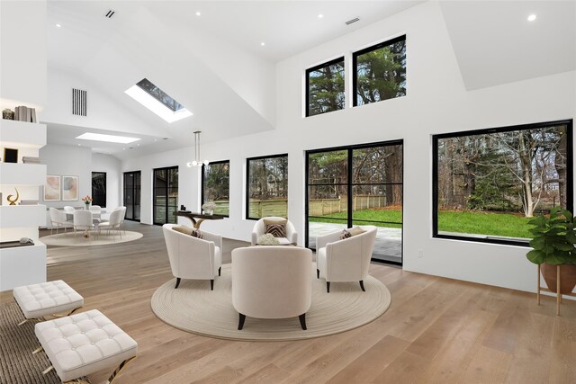 interior space featuring recessed lighting, light wood finished floors, visible vents, a skylight, and high vaulted ceiling
