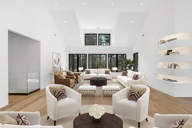 living area featuring recessed lighting, light wood-type flooring, and high vaulted ceiling