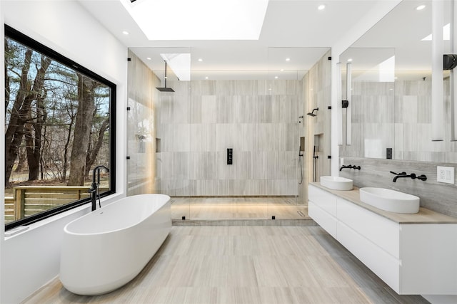 bathroom featuring a tile shower, a sink, and tile walls
