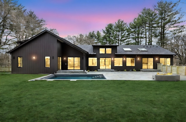 rear view of property with a jacuzzi, an outdoor pool, board and batten siding, a patio area, and a lawn