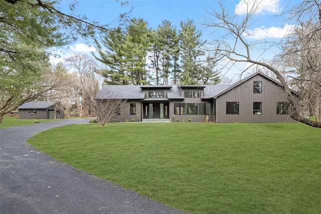 view of front of house with aphalt driveway and a front yard