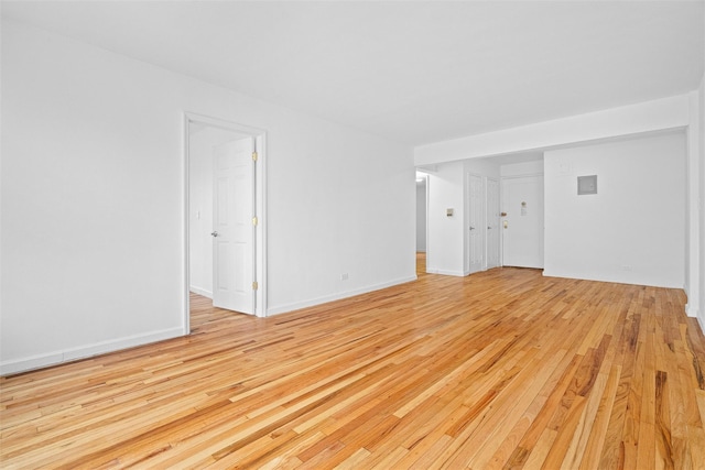 unfurnished room with baseboards and light wood finished floors