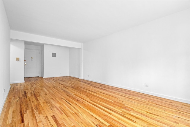 empty room featuring baseboards and light wood-style floors