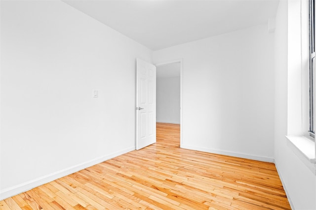 empty room featuring baseboards and hardwood / wood-style flooring