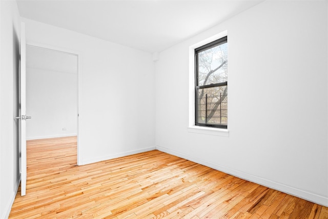 unfurnished room with hardwood / wood-style floors and baseboards