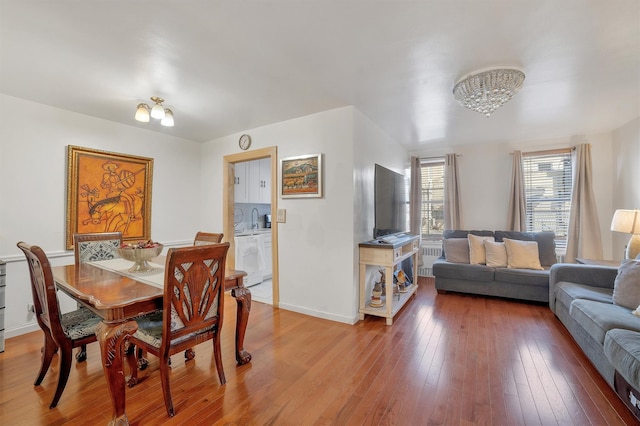 2750 Olinville Ave Unit 1K, Bronx, NY 10467 - dining space with light wood-style flooring, an inviting chandelier, and baseboards