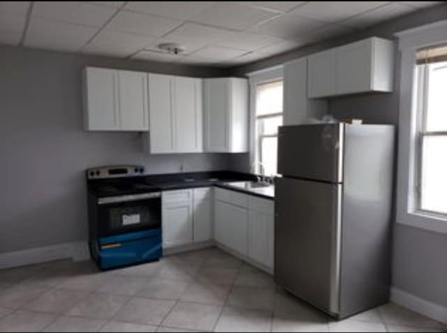 kitchen with white cabinetry, stainless steel appliances, and baseboards