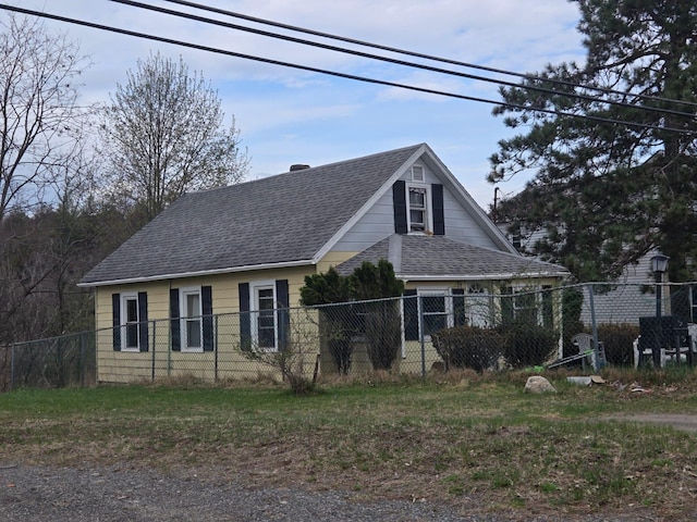 view of home's exterior featuring fence, a chimney, and a shingled roof
