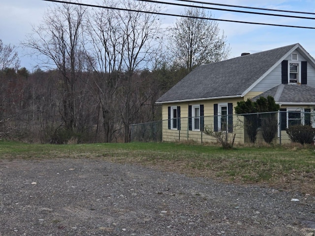 view of front of house with a chimney, fence, and roof with shingles