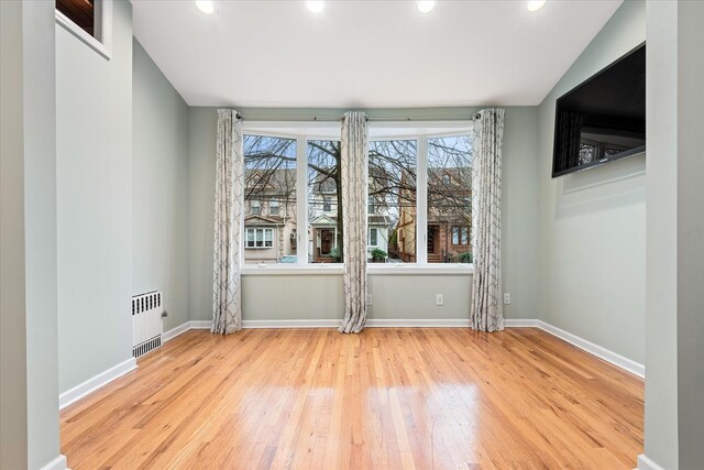 89-21 Aubrey Ave, Glendale, NY 11385 - empty room with radiator heating unit, hardwood / wood-style floors, baseboards, and recessed lighting