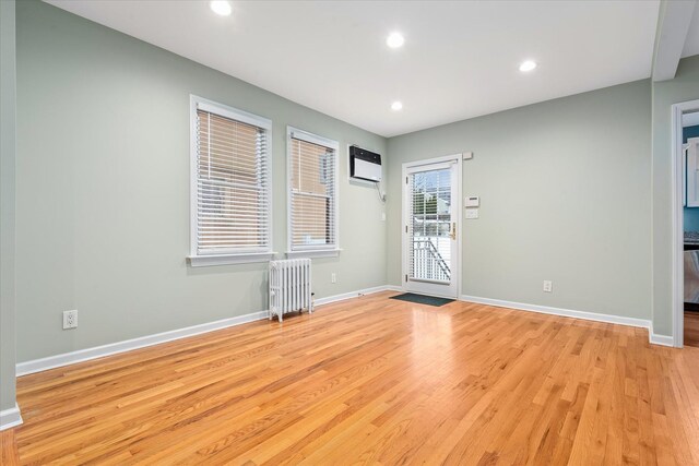 89-21 Aubrey Ave, Glendale, NY 11385 - unfurnished room featuring radiator, light wood-type flooring, recessed lighting, baseboards, and a wall unit AC