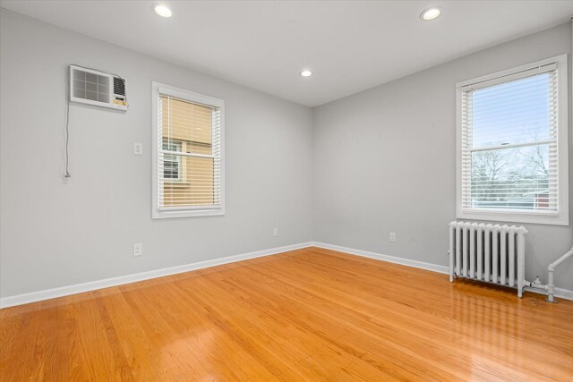 89-21 Aubrey Ave, Glendale, NY 11385 - spare room with radiator, light wood finished floors, baseboards, and recessed lighting