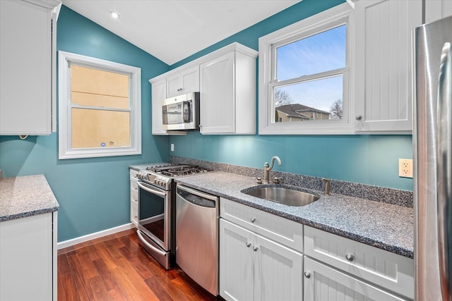 89-21 Aubrey Ave, Glendale, NY 11385 - kitchen featuring appliances with stainless steel finishes, a sink, vaulted ceiling, dark wood-style flooring, and white cabinets