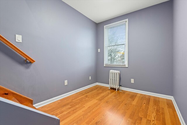 89-21 Aubrey Ave, Glendale, NY 11385 - unfurnished room with radiator heating unit, light wood-style floors, and baseboards
