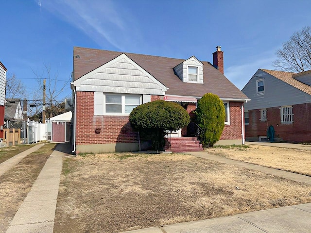 view of front of house with brick siding and a chimney