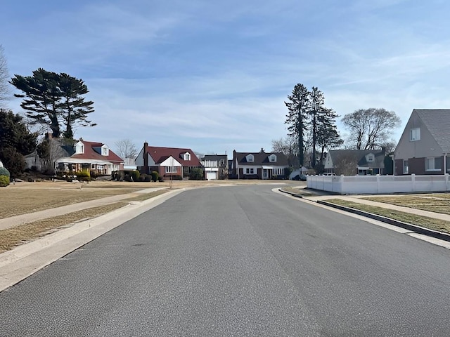 view of street with sidewalks, a residential view, and curbs