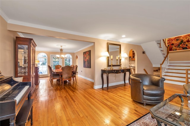 355 Divot Rd, Oceanside, NY 11572 - living room featuring arched walkways, stairway, light wood-type flooring, and a notable chandelier