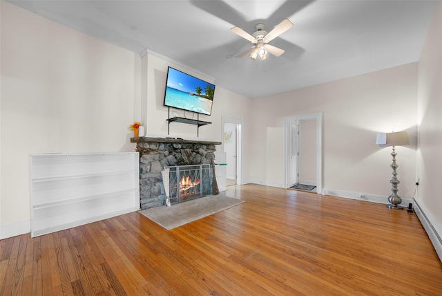 unfurnished living room featuring baseboards, ceiling fan, a fireplace, and hardwood / wood-style flooring