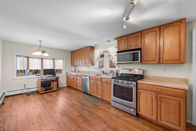 kitchen featuring appliances with stainless steel finishes, light countertops, light wood-style floors, and a sink