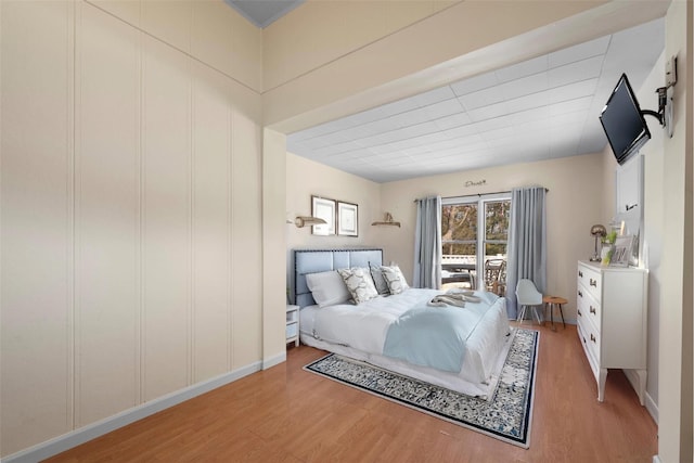 bedroom with access to exterior and light wood-style flooring