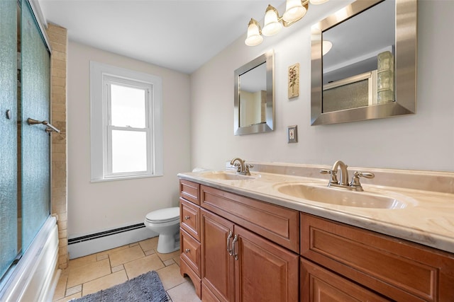 full bathroom with a sink, a baseboard heating unit, toilet, and double vanity