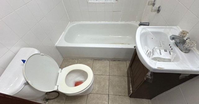 181-10 93rd Ave, Hollis, NY 11423 - bathroom featuring tile walls, tile patterned flooring, toilet, and a bath