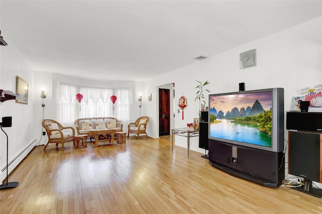 living area featuring visible vents, a baseboard radiator, and hardwood / wood-style floors