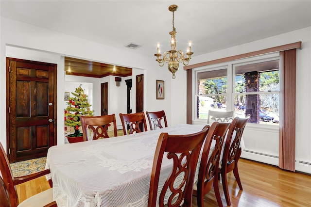 dining room with a notable chandelier, visible vents, and light wood-type flooring